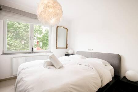 Sandweiler的住宿－Luminous Penthouse with Open Sky Terrace，卧室配有一张白色的床,上面有书
