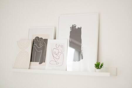 a white shelf with two pictures on it at Modern 2BR Apt in Sandweiler with Terrace in Sandweiler