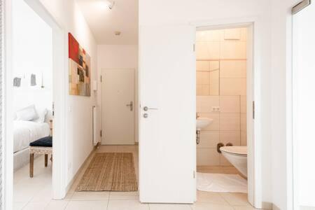 a white bathroom with a tub and a bed at Luminous Penthouse with Open Sky Terrace in Sandweiler