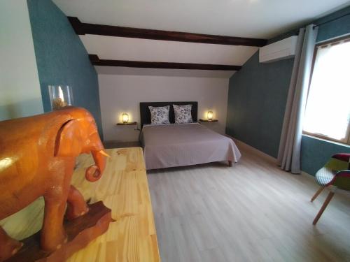 - une chambre avec un lit et une statue de cheval au rez-de-chaussée dans l'établissement Lucinkas, à La Tour-sur-Orb