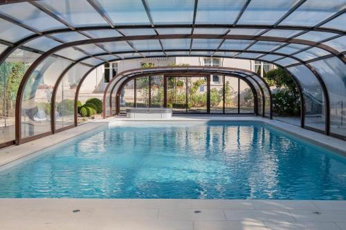 an indoor swimming pool with an archway in a building at Villa Castalie - Maison de maître, grande piscine et jacuzzi, classée 5 étoiles in Montrichard