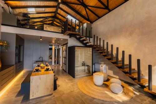 an open kitchen and living room with a spiral staircase at Spa Villas Nafpaktos in Nafpaktos