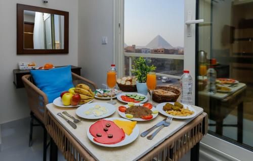 einen Tisch mit Teller mit Lebensmitteln drauf in der Unterkunft Diamond Pyramids View Inn in Kairo