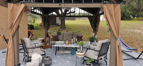 a gazebo with a table and chairs under it at Charming Country Retreat Home in Clermont