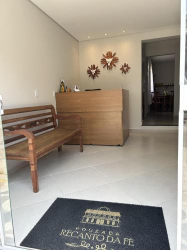 a living room with a bench and a dresser at Pousada Recanto Da Fé in Aparecida