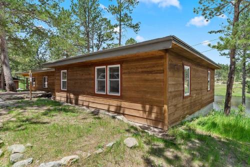 a small wooden cabin in a field with trees at Hottub Hideaway BHBungalows #6 in Custer