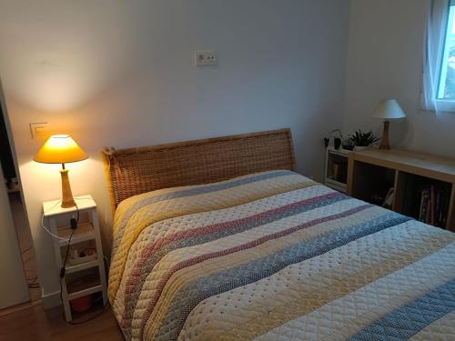 ein Schlafzimmer mit einem Bett und einer Lampe auf einem Nachttisch in der Unterkunft Casita independiente con jardin in Cercedilla