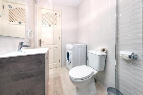 uma casa de banho branca com um WC e um lavatório em Casa Appia-300m from the beach, heated pool em Puerto del Carmen