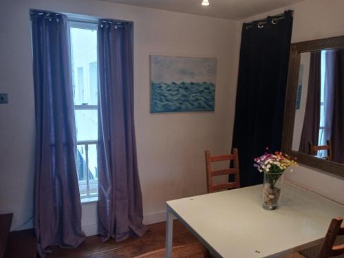 布萊頓霍夫的住宿－Number Five，一间用餐室,配有紫色窗帘和鲜花桌