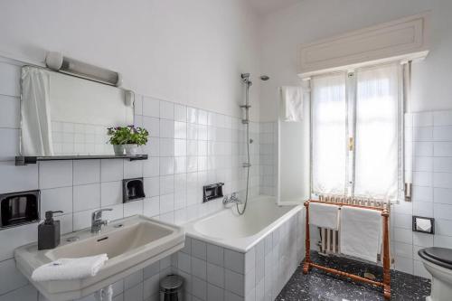 Baño blanco con bañera y lavamanos en Historic Italian House in Val Grande near Lake Maggiore, en Premosello Chiovenda