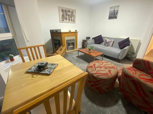 ein Wohnzimmer mit einem Tisch und einem Sofa in der Unterkunft Duloch Bridge View in Dunfermline