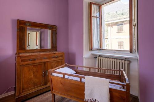 a bedroom with a mirror and a dresser and a window at Historic Italian House in Val Grande near Lake Maggiore in Premosello Chiovenda
