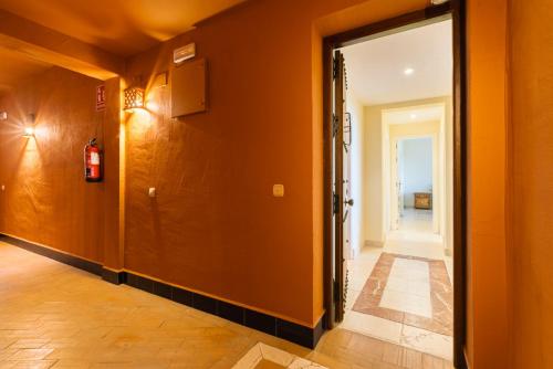 an orange hallway with a fire extinguisher on the wall at Royal Flamingos Sea View Apartman in Estepona