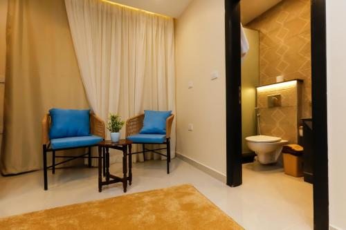 a bathroom with two blue chairs and a toilet at Diamond Pyramids View Inn in Cairo