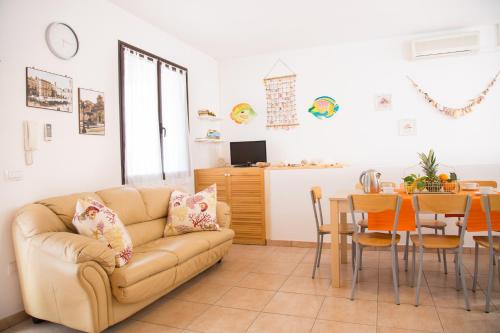 ein Wohnzimmer mit einem Sofa und einem Tisch in der Unterkunft Villetta Concetta in Marina di Pescoluse