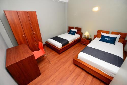 Habitación pequeña con 2 camas y escritorio. en HOSTAL LANCELOT, en Chiclayo