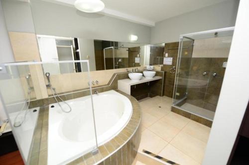 a bathroom with a tub and two sinks and a shower at HOSTAL LANCELOT in Chiclayo