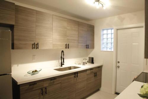 a kitchen with wooden cabinets and a sink at Apt 2 Miami Designer Apartment in the Upper East-Side in Miami