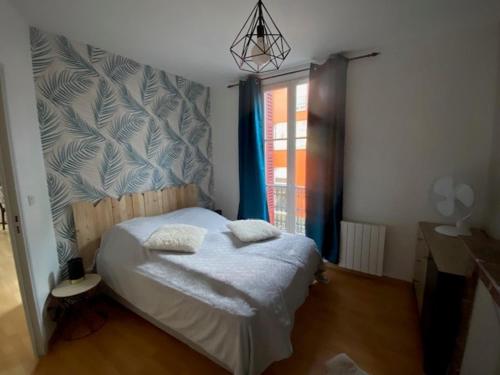 een slaapkamer met een bed met 2 kussens erop bij NOUVEAU: Charmant appartement de 35m² in Mers-les-Bains