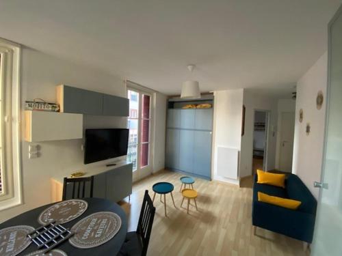 een woonkamer met een tafel en een woonkamer met een bank bij NOUVEAU: Charmant appartement de 35m² in Mers-les-Bains