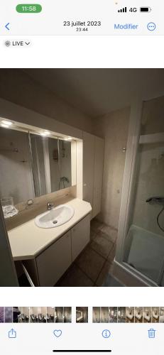 La salle de bains est pourvue d'un lavabo, d'un miroir et d'une douche. dans l'établissement Résidence appartement Oostende, à Ostende