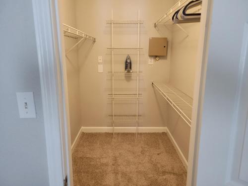 a walk in closet with a glass shelf at Best of Both Worlds in Houston