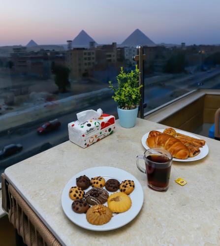 two plates of pastries on a table with a view at Diamond Pyramids View Inn in Cairo