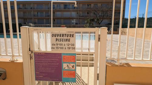 a sign on a gate in front of a building at studio avec coin nuit, 100 m de la mer in Le Lavandou