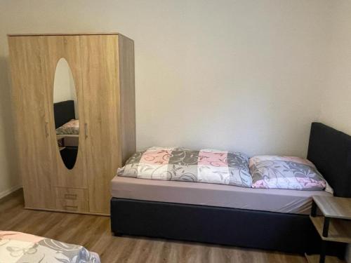 a small bedroom with a bed and a mirror at Hotel Weibertreu in Weinsberg