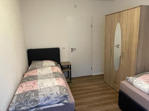 a bedroom with a bed and a dresser and a mirror at Hotel Weibertreu in Weinsberg