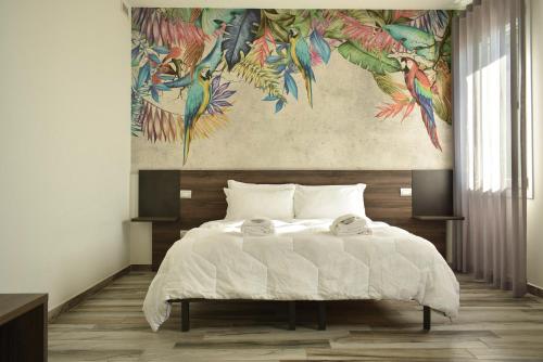 a bedroom with a bed with a painting on the wall at Royal Garden luxury rooms in Padova