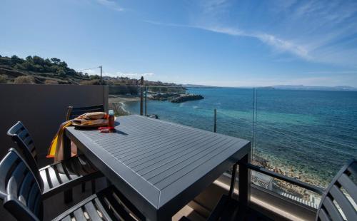 a table and chairs on a balcony with the ocean at ALPHA SUITES in Chania Town