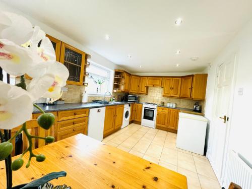 a kitchen with wooden cabinets and a wooden table at Tillicoultry Jupiter Apartment - Scotland Holiday Let in Tillicoultry
