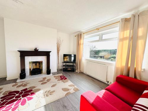 a living room with a red couch and a fireplace at Tillicoultry Jupiter Apartment - Scotland Holiday Let in Tillicoultry