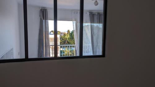 a window with a view of a balcony at studio avec coin nuit, 100 m de la mer in Le Lavandou