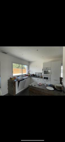 une cuisine avec des appareils blancs et une grande fenêtre dans l'établissement Villa luxe Meyer’s beach, à Pinet