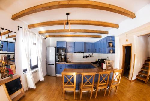 une cuisine avec des placards bleus et une table en bois dans l'établissement Vama Chalet, à Molidu