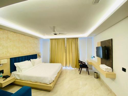 a hotel room with a bed and a tv at Hotel Holiday Grand in Greater Noida