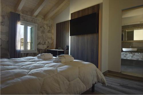 a bedroom with a large white bed and a television at Royal Garden luxury rooms in Padova
