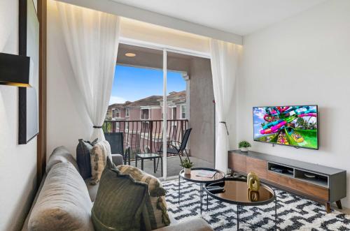 a living room with a couch and a tv at Updated Condo Near Conv Ctr, I-Drive & Universal in Orlando