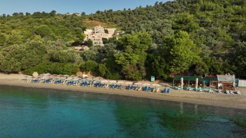 a group of chairs and umbrellas on a beach at Golden King Villas in Vassilias