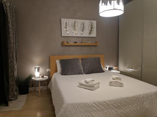 a bedroom with a bed with towels on it at Gaia St Paul's Bay Modern Cosy Apartment Qawra Bugibba in St. Paul's Bay