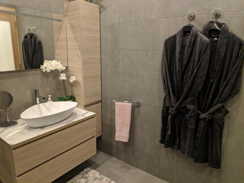 a bathroom with a sink and a mirror at Gaia St Paul's Bay Modern Cosy Apartment Qawra Bugibba in St. Paul's Bay