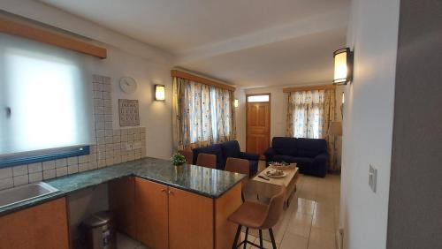 a kitchen and living room with a table and chairs at Maryland Lodge kakopetria in Kakopetria