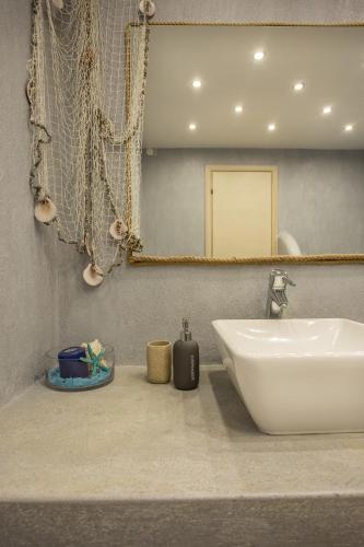 a bathroom with a white sink and a mirror at Golden King Villas in Vassilias