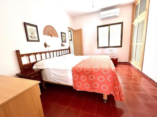 a bedroom with a large bed with a red floor at Villa Skiba Es Caló Formentera in Es Calo