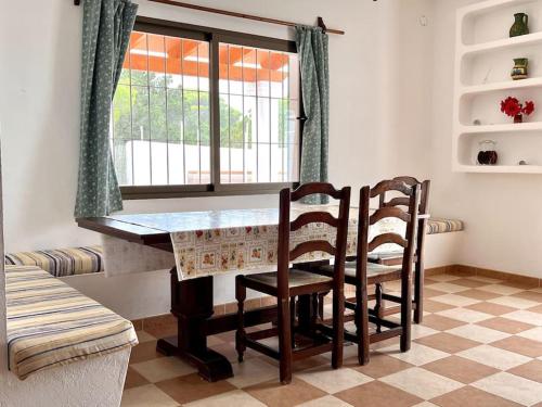 a dining room table with two chairs and a window at Villa Skiba Es Caló Formentera in Es Calo