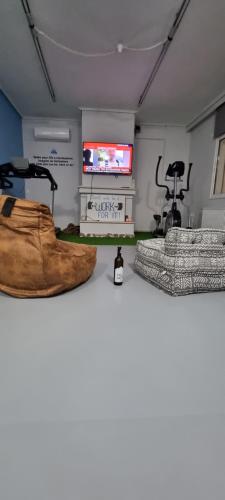 a room with a gym with a treadmill and a television at Μεγάλος χώρος με Γυμναστήριο-Χαμάμ-Κρεβάτι-Γραφείο in Krionérion
