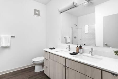 a white bathroom with a sink and a toilet at CozySuites 2BD Bottleworks Indianapolis #2 in Indianapolis