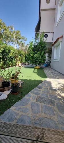 a garden with a lawn with plants and a building at Μεγάλος χώρος με Γυμναστήριο-Χαμάμ-Κρεβάτι-Γραφείο in Krionérion
